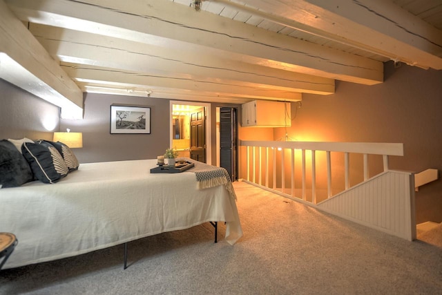 carpeted bedroom with beam ceiling