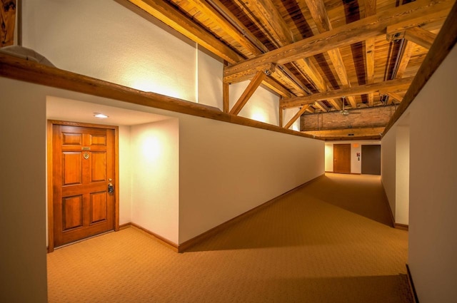 hall with baseboards, carpet, wooden ceiling, and beamed ceiling