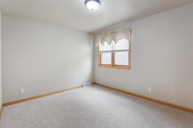 unfurnished room featuring baseboards, carpet floors, and visible vents