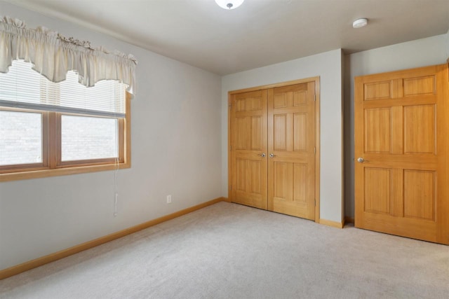 unfurnished bedroom with a closet, carpet, and baseboards