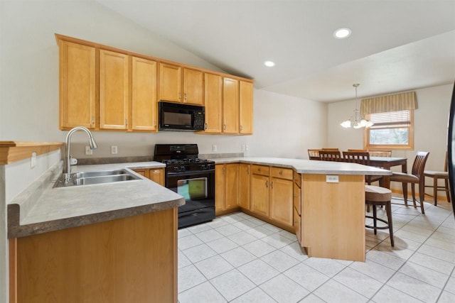 kitchen featuring a sink, a peninsula, light tile patterned floors, a kitchen bar, and black appliances