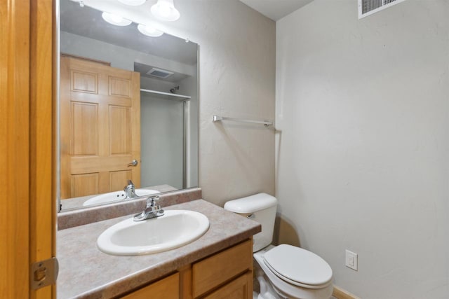 bathroom featuring an enclosed shower, vanity, toilet, and visible vents