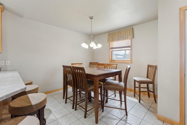 dining area featuring baseboards, light tile patterned floors, and a notable chandelier