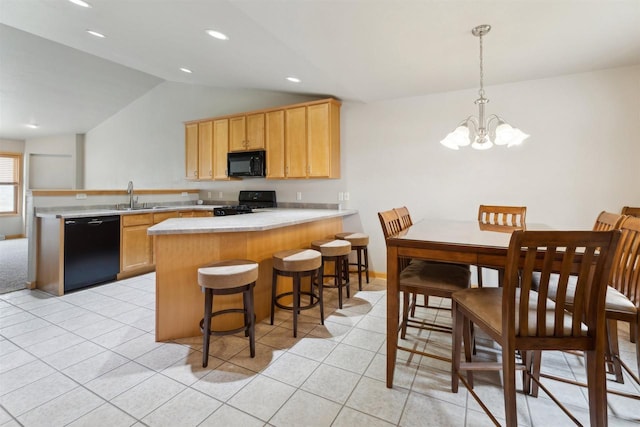kitchen with a peninsula, lofted ceiling, a sink, and black appliances