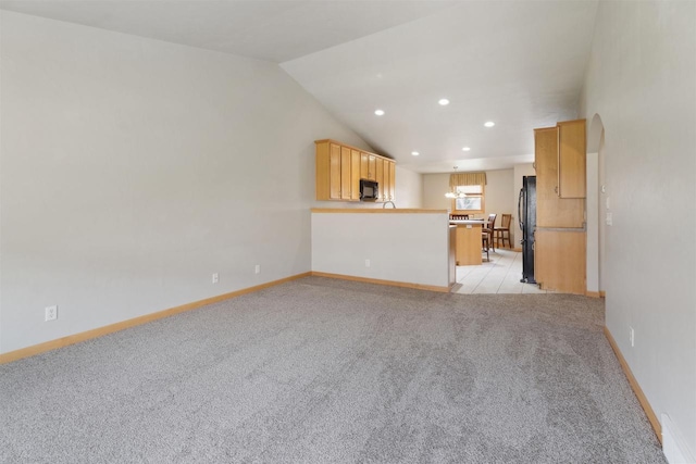unfurnished living room featuring recessed lighting, baseboards, vaulted ceiling, and light carpet