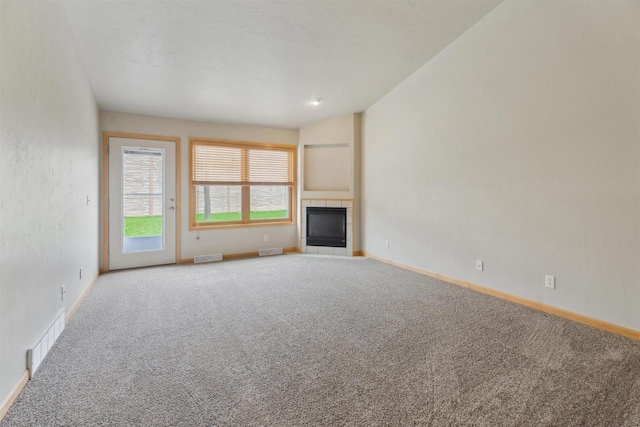 unfurnished living room featuring baseboards, visible vents, and carpet
