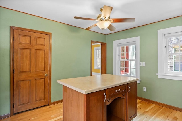 126 S Hancock St, Madison, WI 53703 - kitchen featuring light wood finished floors, light countertops, baseboards, ceiling fan, and a kitchen island