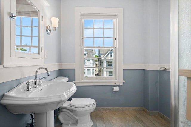 126 S Hancock St, Madison, WI 53703 - half bath featuring wood finished floors, healthy amount of natural light, toilet, and baseboards