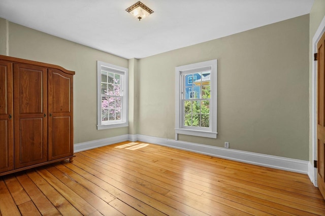 126 S Hancock St, Madison, WI 53703 - unfurnished bedroom with multiple windows, baseboards, and light wood finished floors