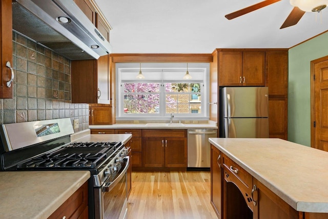 126 S Hancock St, Madison, WI 53703 - kitchen featuring appliances with stainless steel finishes, exhaust hood, a sink, and brown cabinets