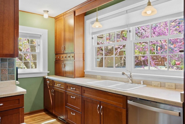 126 S Hancock St, Madison, WI 53703 - kitchen with stainless steel dishwasher, a sink, light countertops, and decorative light fixtures