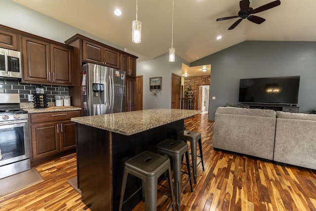 351 Alyssa St, Tomah, WI 54660 - kitchen featuring wood finished floors, open floor plan, appliances with stainless steel finishes, and lofted ceiling