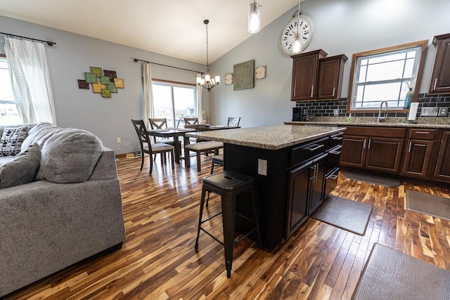 351 Alyssa St, Tomah, WI 54660 - kitchen featuring an inviting chandelier, decorative backsplash, a kitchen island, open floor plan, and dark wood finished floors