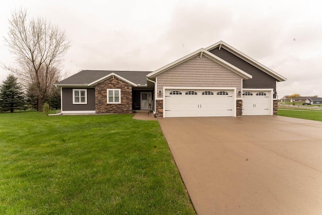 351 Alyssa St, Tomah, WI 54660 - craftsman-style home featuring an attached garage, stone siding, driveway, and a front yard