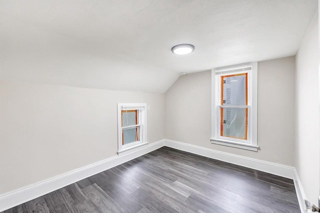 bonus room with baseboards, vaulted ceiling, and dark wood-style flooring