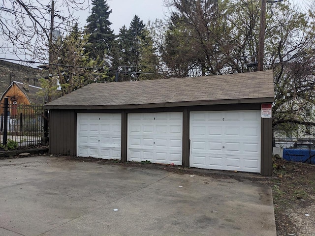 detached garage featuring fence
