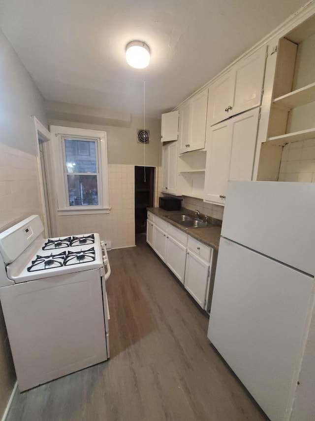 kitchen featuring a sink, dark wood-style flooring, white appliances, and white cabinetry