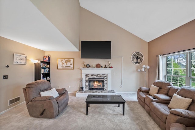 living room featuring visible vents, baseboards, a fireplace, and high vaulted ceiling