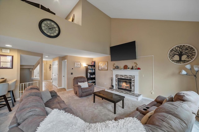 living area with baseboards, carpet flooring, a fireplace, and high vaulted ceiling