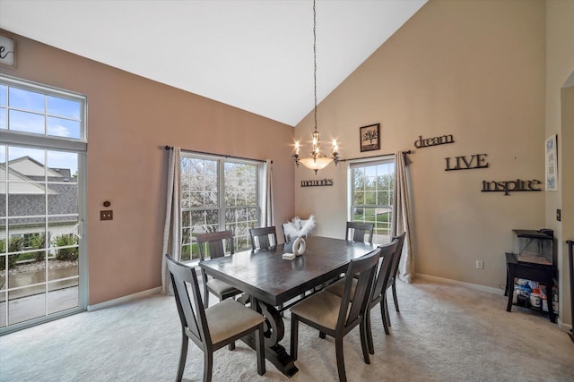 dining area with high vaulted ceiling, baseboards, light carpet, and a notable chandelier