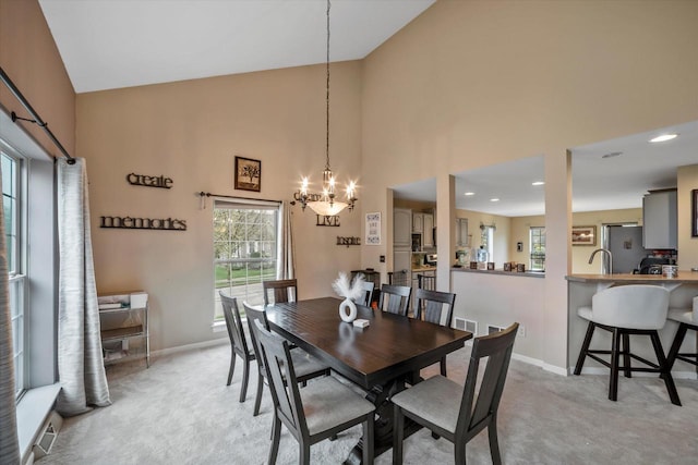 dining room featuring baseboards, high vaulted ceiling, light colored carpet, and a wealth of natural light
