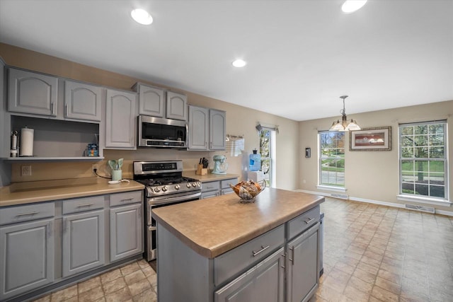 kitchen with stainless steel appliances, gray cabinetry, plenty of natural light, and visible vents