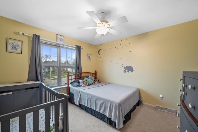bedroom with ceiling fan, visible vents, light carpet, and baseboards