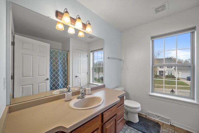 bathroom with visible vents, a healthy amount of sunlight, and vanity