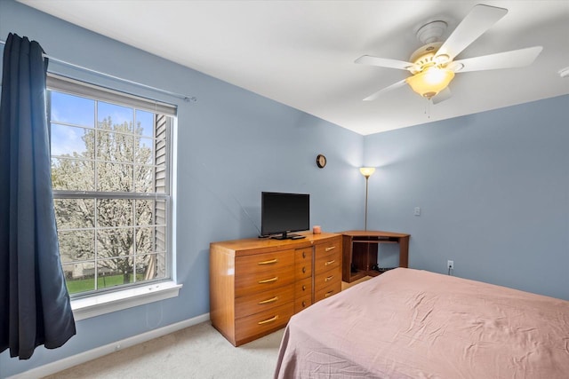 bedroom featuring baseboards, ceiling fan, and light carpet