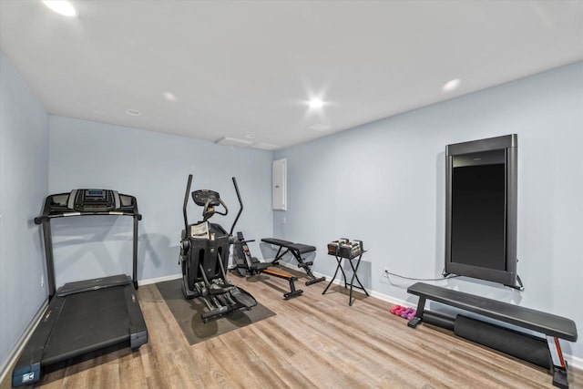 workout room featuring baseboards, recessed lighting, and wood finished floors