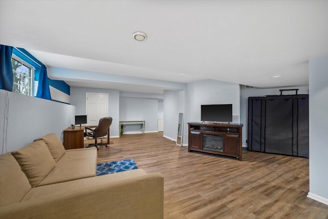 living area with baseboards and wood finished floors
