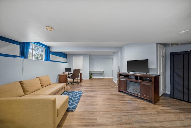 living area featuring light wood-style floors, baseboards, and visible vents