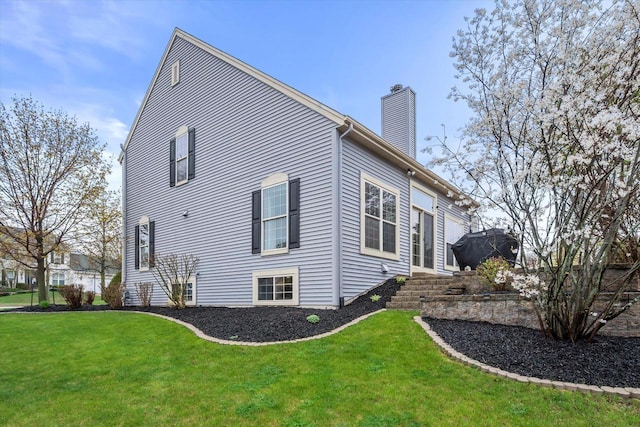 view of home's exterior with a lawn and a chimney