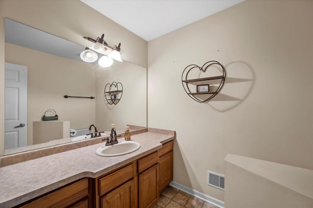 bathroom featuring baseboards, visible vents, and vanity
