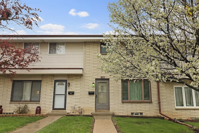townhome / multi-family property featuring a front lawn