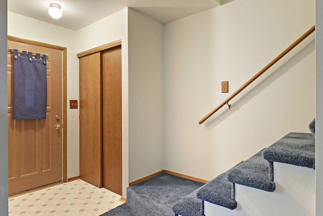 foyer featuring elevator, baseboards, carpet flooring, and stairs