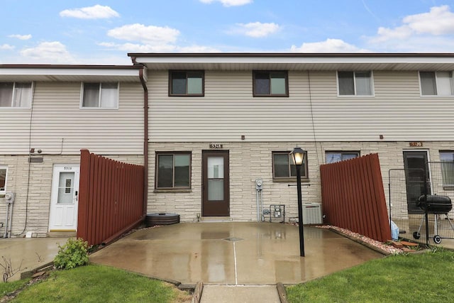 rear view of house with a patio area and fence