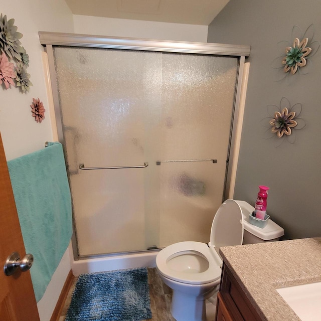 bathroom featuring toilet, a shower stall, wood finished floors, and vanity