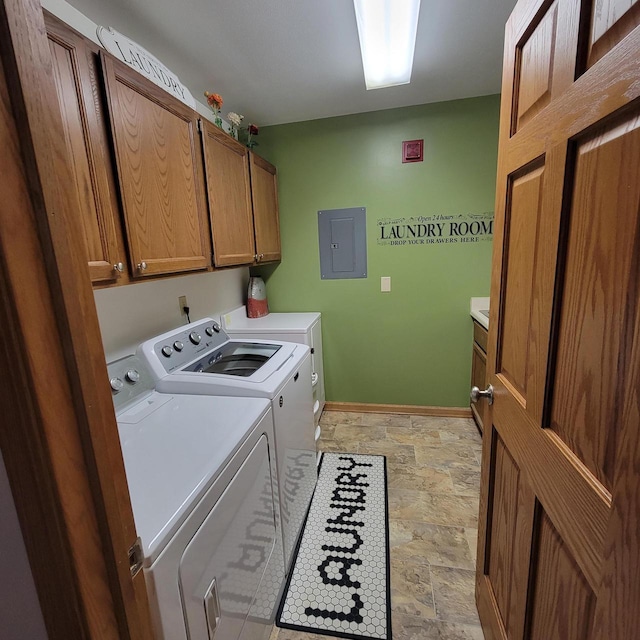 laundry area with cabinet space, stone finish floor, baseboards, washer and clothes dryer, and electric panel