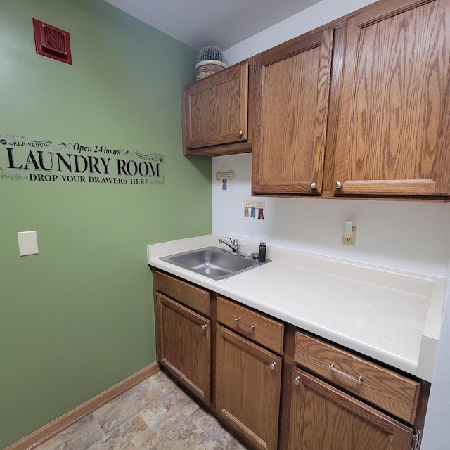 interior space featuring baseboards, stone finish flooring, and a sink