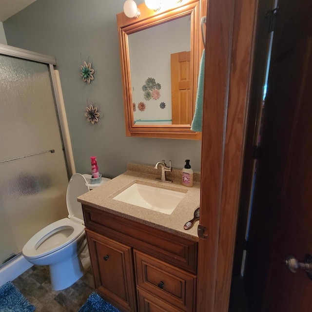 bathroom featuring vanity, toilet, and a stall shower