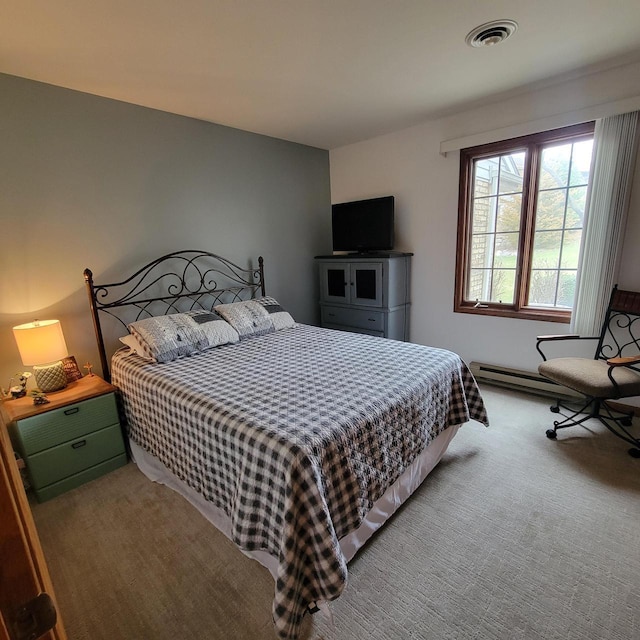 bedroom with carpet floors, a baseboard heating unit, and visible vents