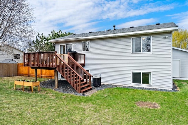 rear view of property featuring a lawn, a wooden deck, central AC, fence, and stairs
