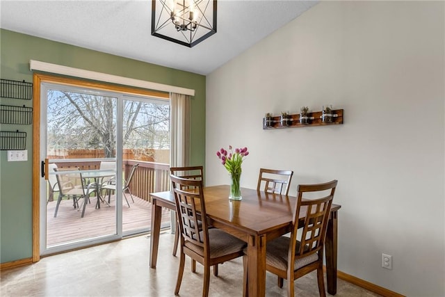 dining room featuring baseboards, light floors, and a chandelier
