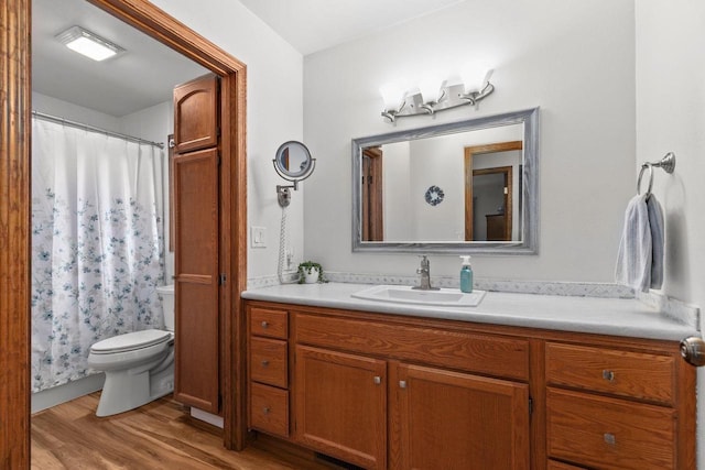 bathroom with vanity, curtained shower, toilet, and wood finished floors