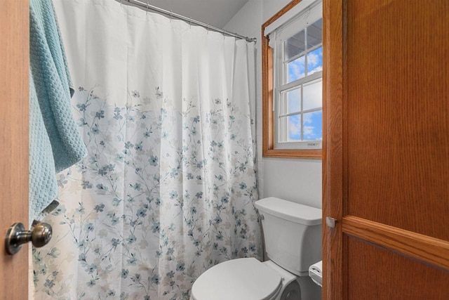 bathroom with a shower with curtain and toilet