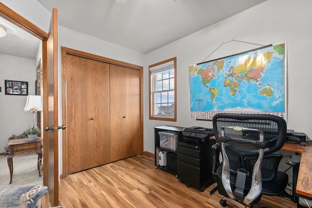 home office with baseboards and light wood-type flooring