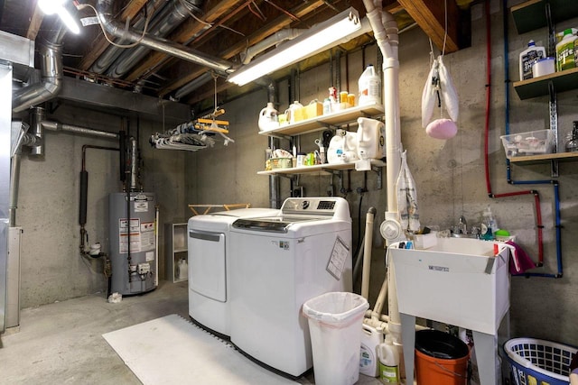 laundry room with laundry area, washing machine and dryer, a sink, and water heater