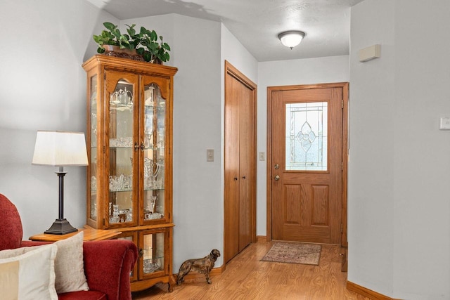 entryway with baseboards and light wood-style flooring