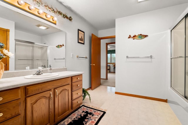 full bathroom with vanity, tile patterned floors, baseboards, and a shower with door